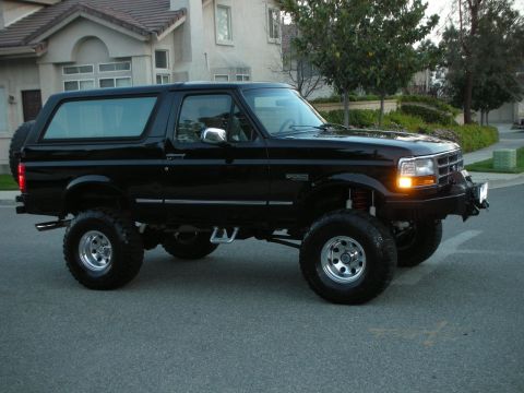 1996 Ford Bronco - This lifted 1996 Ford Bronco is parked on a residential street, showing its modified suspension and bumper.