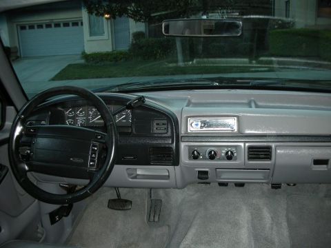 1996 Ford Bronco - The interior of a 1992 Ford Bronco, a gray dashboard and steering wheel, with a garage visible through the windshield.