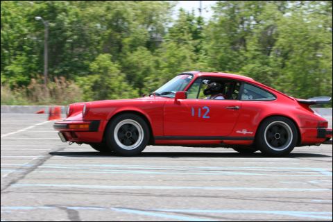 2001 Mercury Grand Marquis - A red Porsche 911 with racing number 112 participates in an autocross event.