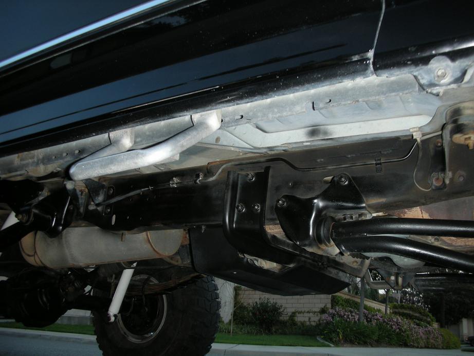 Underside view of a truck showing suspension components and exhaust system