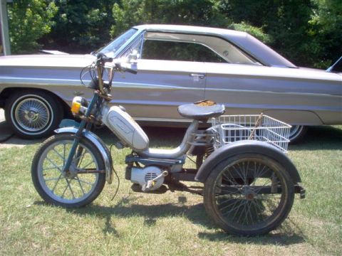 1973 Ford Ranchero - A three-wheeled moped sits in front of a classic 1964 Ford Galaxie 500.