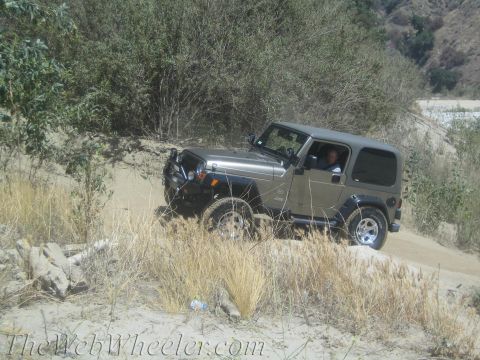 1987 Suzuki Samurai - A Jeep Wrangler navigates a dirt path in a dry, brushy environment.