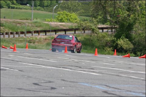 2001 Mercury Grand Marquis - A red car navigates an autocross course marked by orange cones.