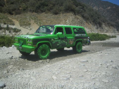 1987 Suzuki Samurai - This heavily modified SUV features a vibrant green paint job with custom Hulk-themed graphics and aggressive off-road tires, seen navigatin…