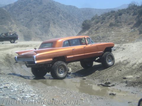 1987 Suzuki Samurai - This lifted limousine navigates a muddy off-road course, far from its typical urban environment.