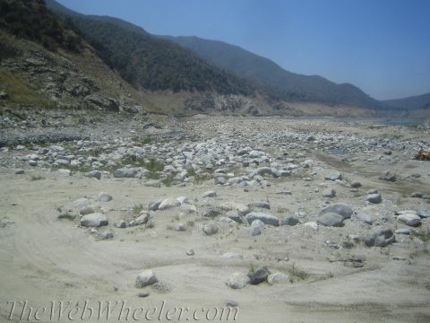1987 Suzuki Samurai - Dry riverbed landscape with mountains and a distant ATV.