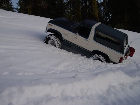 1986 Ford Bronco - A 1986 Ford Bronco navigates deep snow, with a red gas can mounted on the rear.