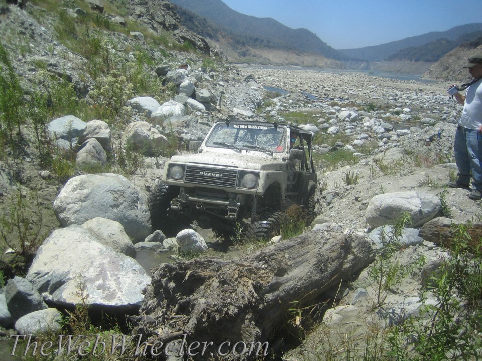 Suzuki Samurai navigating a rocky, dry riverbed