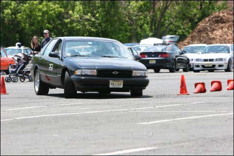 2001 Mercury Grand Marquis - Black Chevrolet Caprice navigates an autocross course with other vehicles in the background.