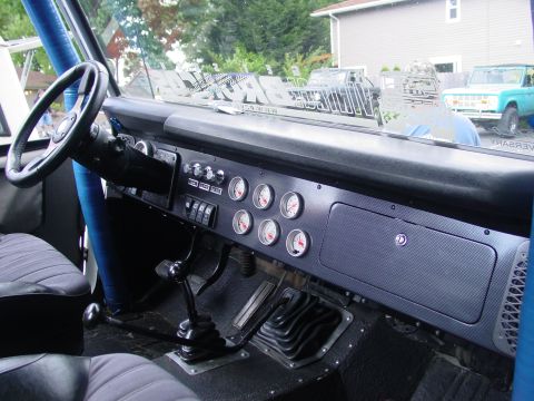 1973 Ford Bronco - The interior of a 1973 Ford Bronco, a custom dashboard with multiple gauges and a prominent gear shifter.