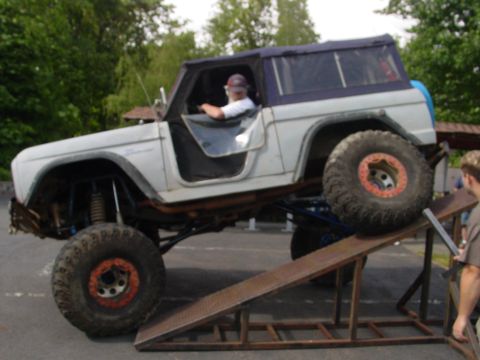 1973 Ford Bronco - A modified 1973 Ford Bronco is positioned on a ramp, with a person driving.