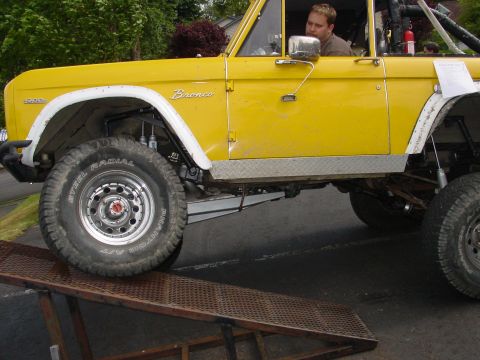1973 Ford Bronco - A yellow 1973 Ford Bronco is shown from the side as it drives up a ramp.