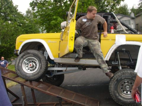 1973 Ford Bronco - A man exits a yellow 1973 Ford Bronco as it sits on a ramp.
