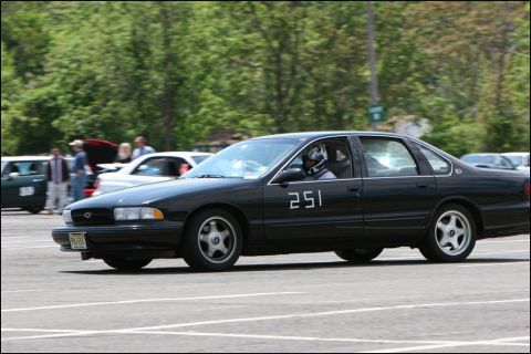 2001 Mercury Grand Marquis - A black sedan with racing number 251 is seen on a track with other cars and spectators.