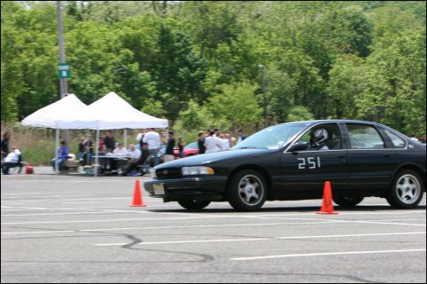 2001 Mercury Grand Marquis - A black sedan, marked with the number 251, navigates an autocross course with orange cones visible.