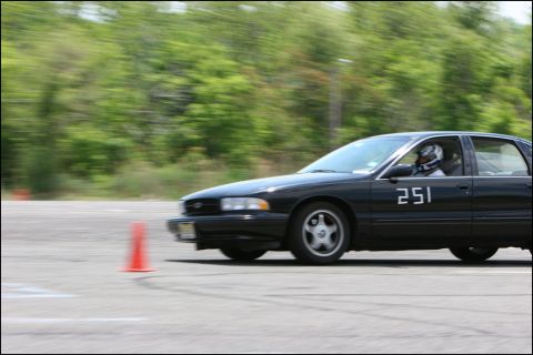 2001 Mercury Grand Marquis - A black sedan navigates a course marked by orange cones during a timed event.