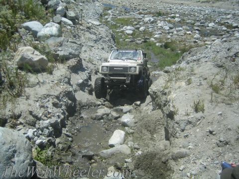 1987 Suzuki Samurai - Suzuki Samurai tackling a challenging off-road course in a dry creek bed.