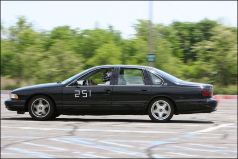 2001 Mercury Grand Marquis - A black sedan with racing number 251 is seen on a race track with a driver wearing a helmet.