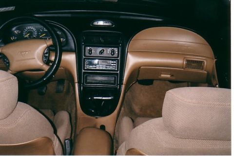 1991 Ford LTD Crown Victoria - The interior of a 1991 Ford Mustang features a tan dashboard and seats.