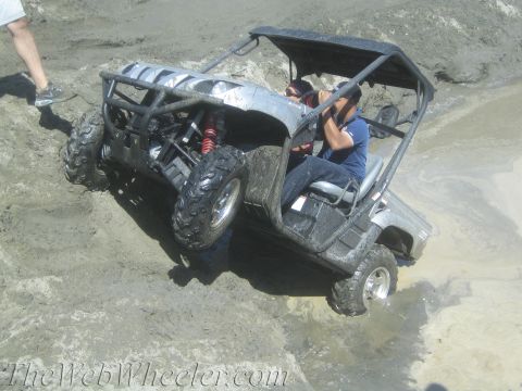 1987 Suzuki Samurai - A side-by-side utility vehicle navigates a challenging muddy terrain.