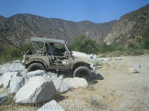 1987 Suzuki Samurai - 1987 Suzuki Samurai tackling rough terrain in a mountainous, rocky area.