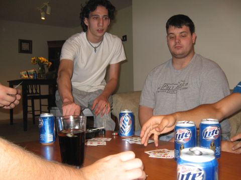 1988 Ford Bronco - A group of friends are engrossed in a card game, surrounded by empty beer cans on the table.
