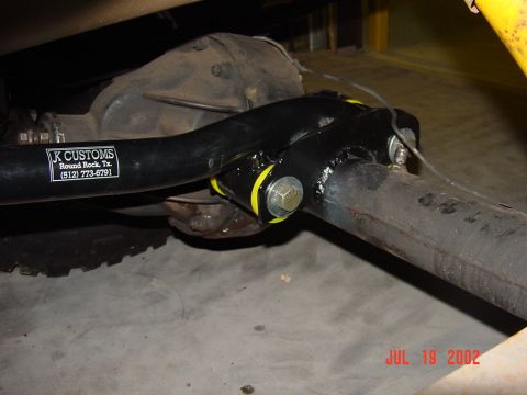1991 Ford Bronco - Aftermarket suspension part with K CUSTOMS sticker on a vehicle axle.