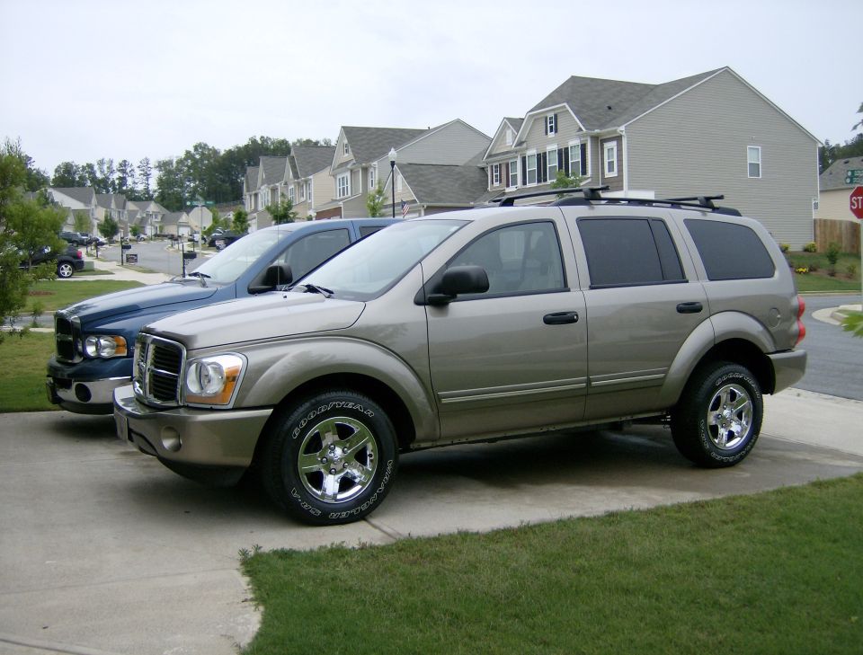 Tan 2004 Dodge Durango 3/4 front view parked next to a blue pickup truck