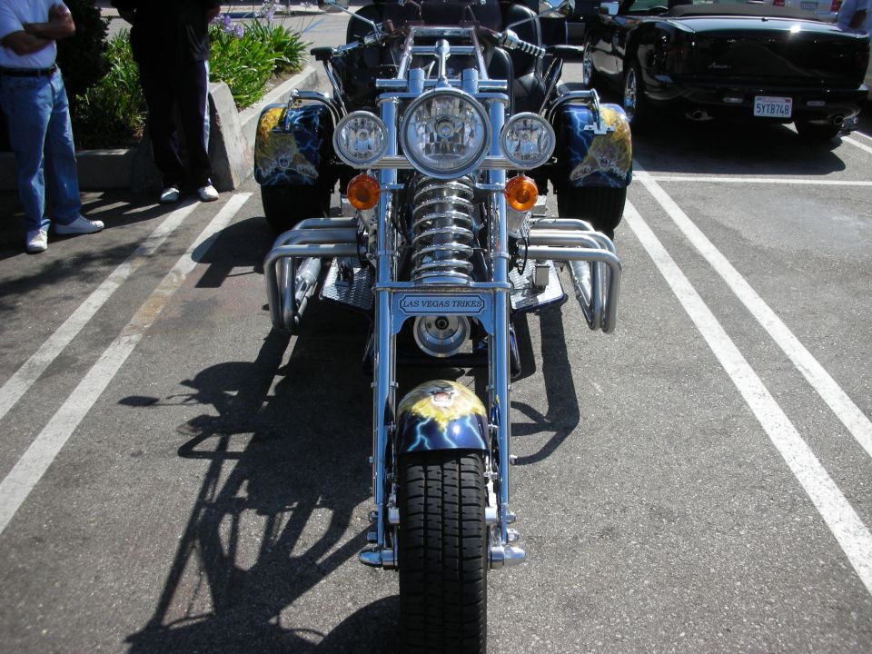 Front view of a custom trike motorcycle with lightning graphics on the fenders and a "Las Vegas Trikes" emblem