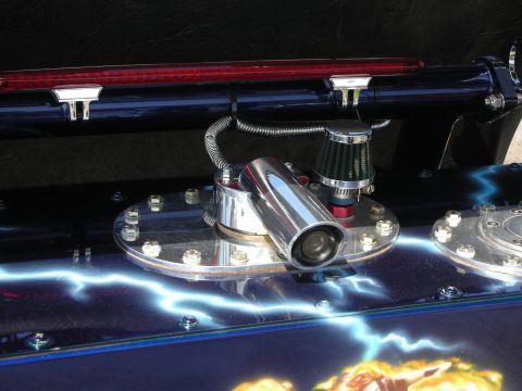 1998 Ford Crown Victoria - A close-up view of a custom fuel tank assembly with chrome detailing and a lightning bolt paint scheme.