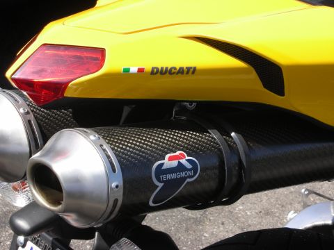 1998 Ford Crown Victoria - Close-up of a yellow motorcycle's tail section, the Ducati logo and a Termignoni exhaust system.