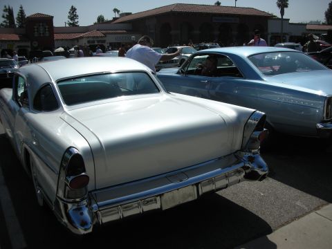 1998 Ford Crown Victoria - Two classic American cars, a white coupe and a blue sedan, parked side-by-side at an outdoor event.