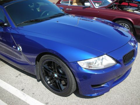 1998 Ford Crown Victoria - A blue BMW Z4 is parked next to a maroon car.