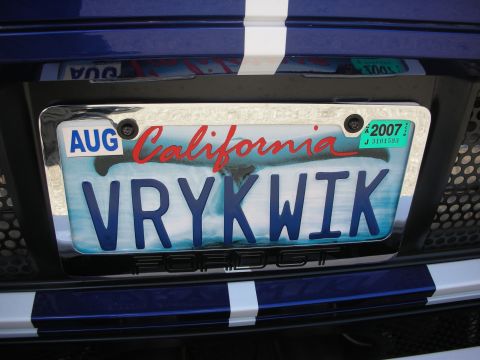 1998 Ford Crown Victoria - Rear view of a blue Ford Mustang GT showing its California license plate and racing stripes.