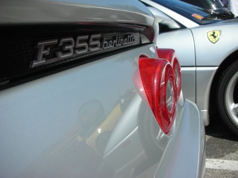 1998 Ford Crown Victoria - A silver Ferrari F355 Berlinetta is parked next to another silver Ferrari with a yellow prancing horse emblem.
