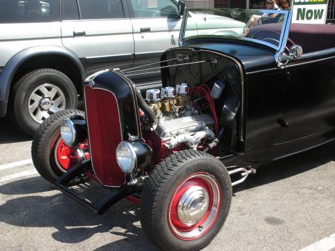 1998 Ford Crown Victoria - Hot rod with a prominent V8 engine and red grille, parked next to a silver SUV.
