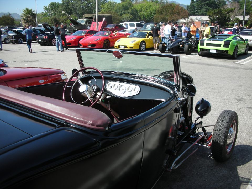 Black hot rod interior with burgundy seats and a chrome steering wheel