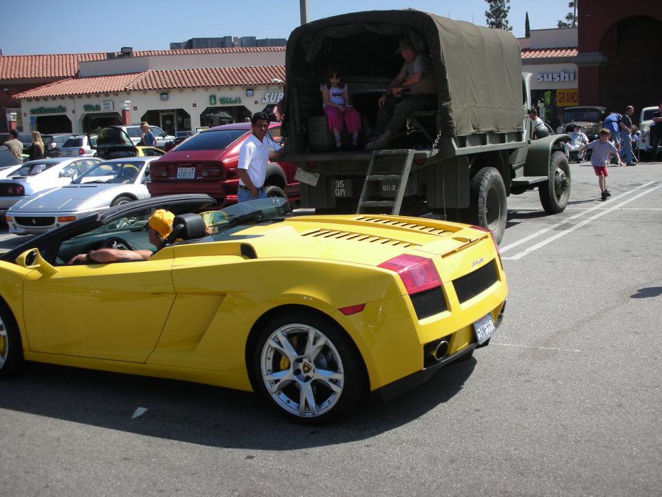 Yellow convertible sports car rear view, parked on asphalt