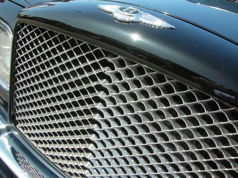 1998 Ford Crown Victoria - The iconic Bentley emblem adorns the front grille of a luxury vehicle.