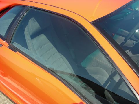 1998 Ford Crown Victoria - Interior view of an orange sports car with grey seats and a black steering wheel.
