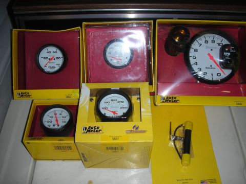 1998 Ford Crown Victoria - Collection of Auto Meter gauges, including a tachometer, fuel, water, and oil pressure gauges, all in their boxes.