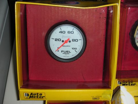 1998 Ford Crown Victoria - A new Auto Meter fuel pressure gauge is displayed in its retail box, ready for installation.