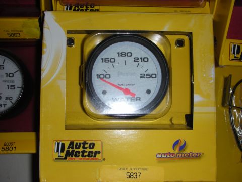 1998 Ford Crown Victoria - An Auto Meter water temperature gauge is shown in its yellow retail packaging, alongside other Auto Meter gauges.