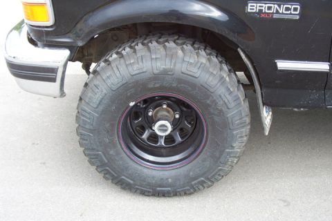 1996 Ford Bronco - Close-up of the front wheel and fender of a 1996 Ford Bronco, showing the tire and bumper.