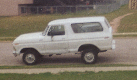 White Ford Bronco SUV in profile on a residential street