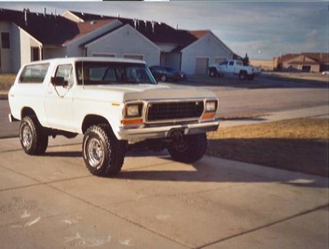 1979 Ford Bronco - White Ford Bronco SUV parked in a suburban driveway with other vehicles visible.