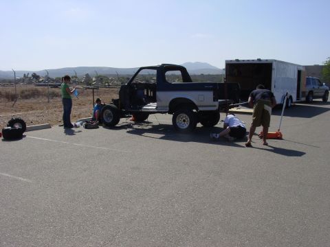1994 Ford Bronco - People working on a disassembled Ford Bronco next to a trailer and another vehicle.