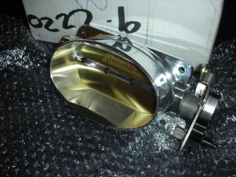 1998 Ford Crown Victoria - A polished aluminum Accufab twin-bore throttle body sitting on bubble wrap in front of its white box, with the brand name machined into the…