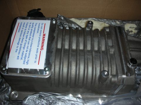 1998 Ford Crown Victoria - A new cast-aluminum supercharger/compressor unit sitting in its shipping box on plastic wrap and foam packing, finned housing still bare me…