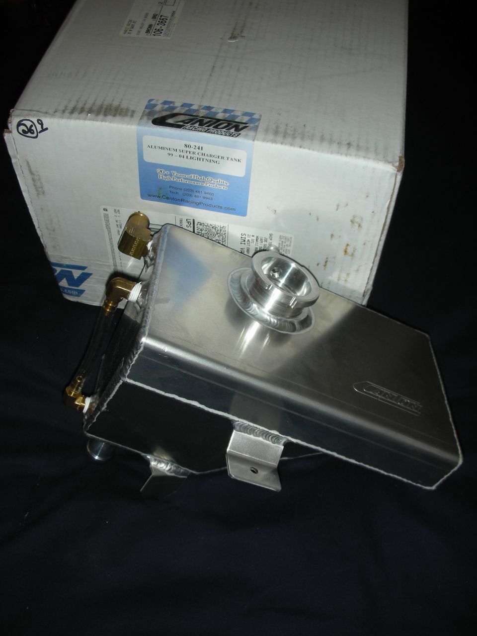 Canton aluminum supercharger coolant tank with brass fittings in front of its labeled box